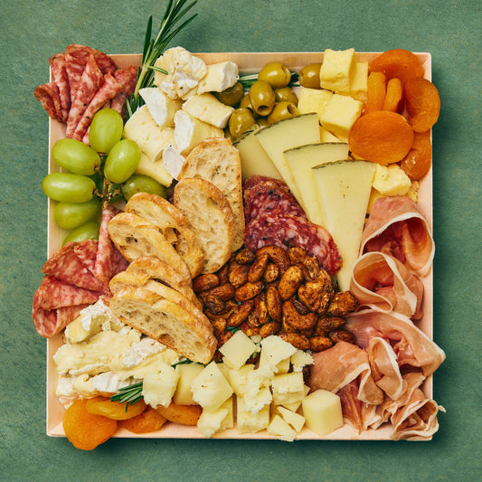 Selection of meats, cheeses, dried fruit, olives, sweet & spicy nuts, and crostini